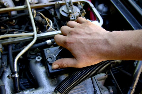 dreamstime_m_172965 A mechanic' hand fixing a car engine