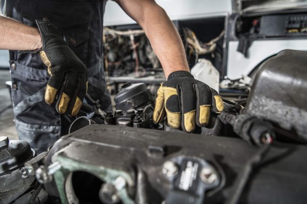 dreamstime_m_198136778 Professional Automotive Caucasian Mechanic Repair Semi Truck Diesel Engine Close Up