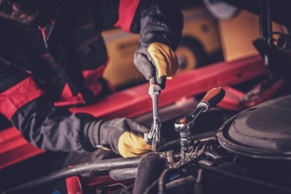 dreamstime_m_207033253 Car Mechanic Repairs Classic Vehicle Engine. Car Mechanic Repairs Classic Vehicle Gasoline Engine Inside His Workshop. Vintage Cars Restoration. Automotive Industry